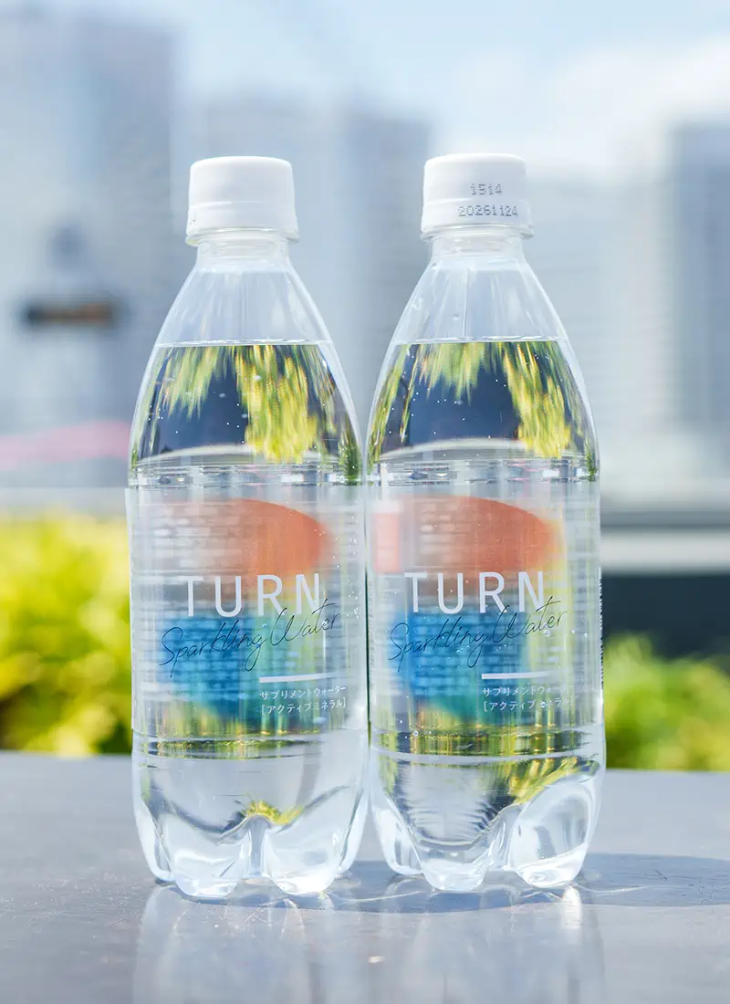 水辺に並ぶ TURN スパークリングウォーターのボトル